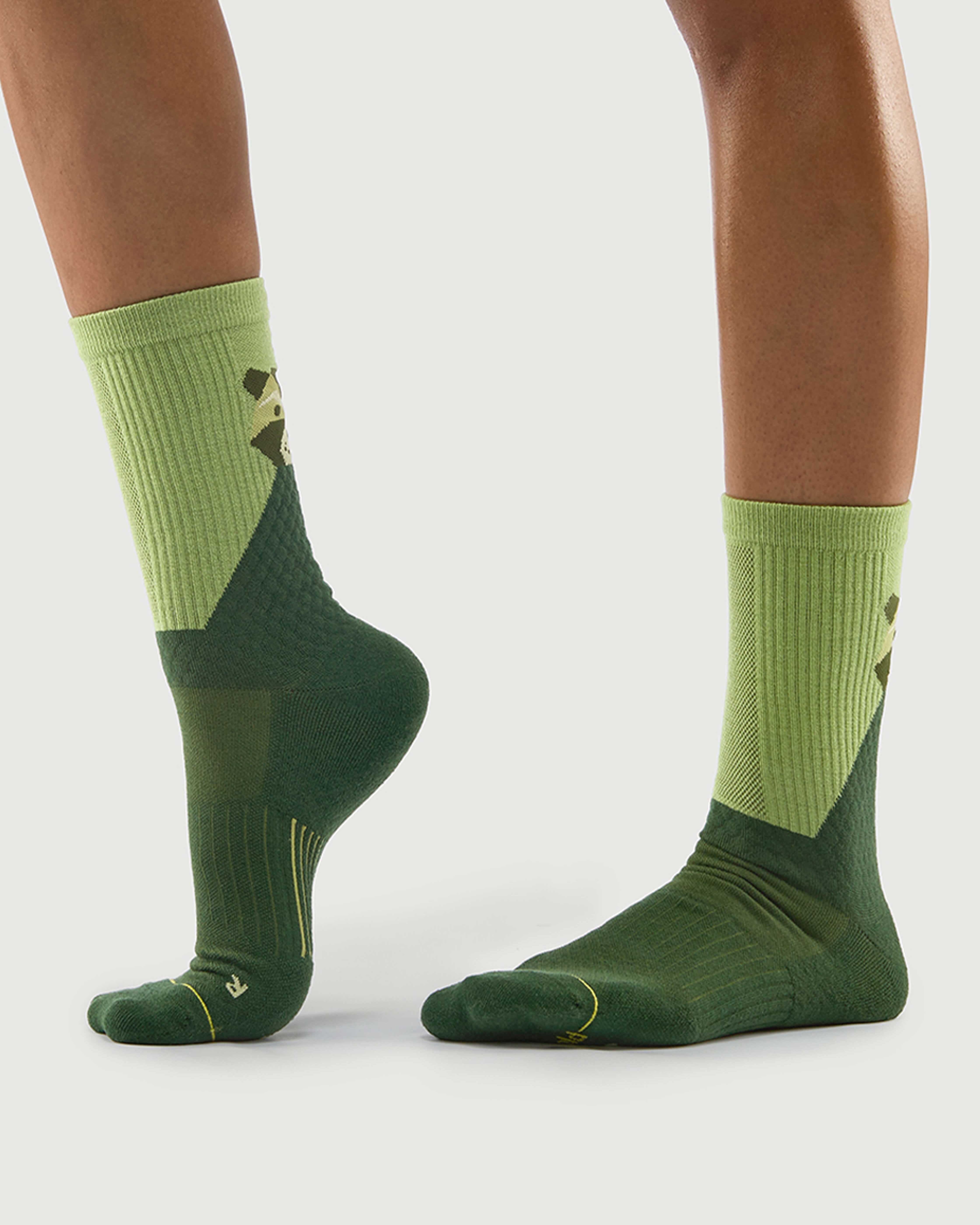 Side view of green Crafty Otter hiking socks on a model, highlighting the color-block design.