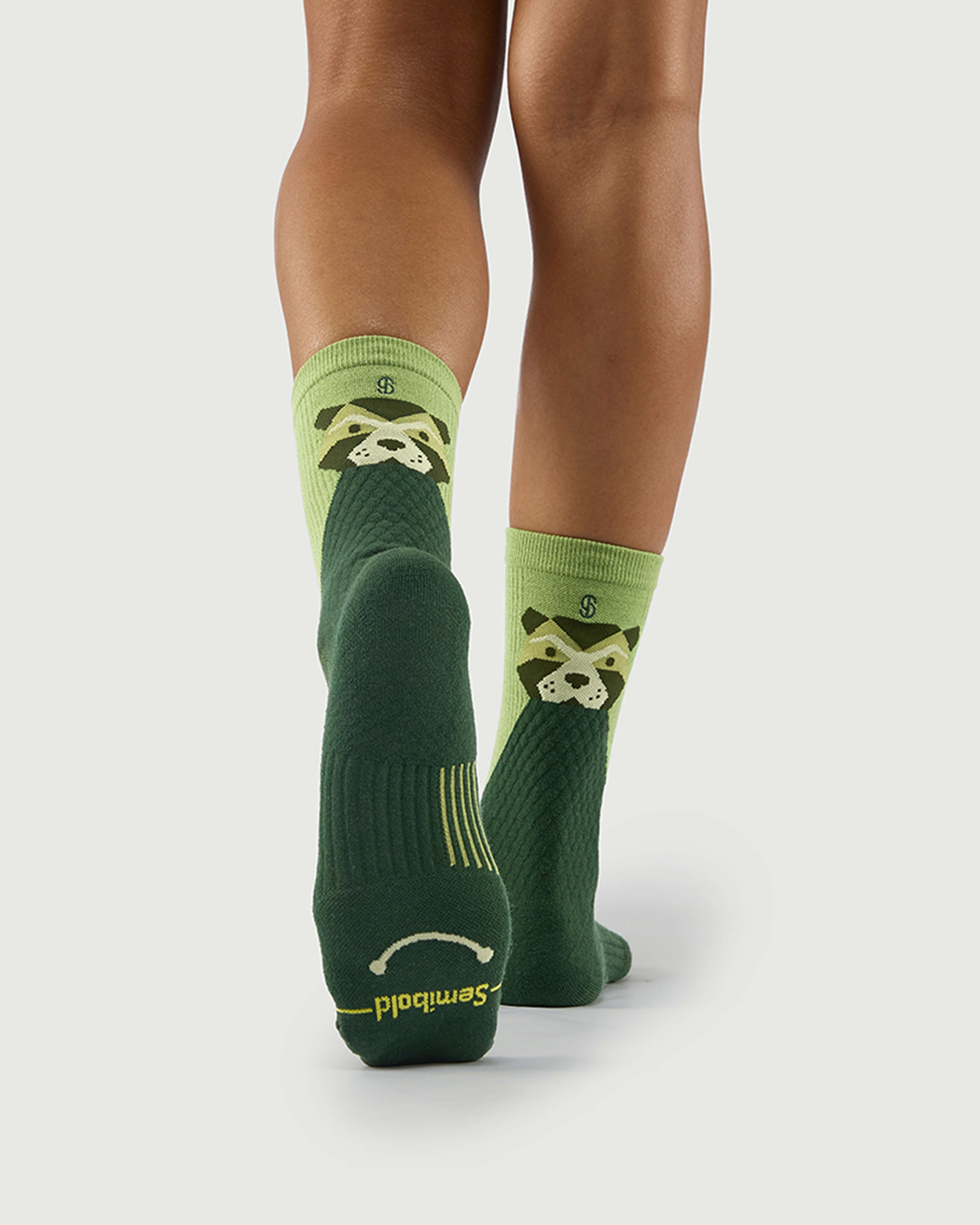 Bottom view of green Crafty Otter socks on a model, showing the technical arch support on the sole.