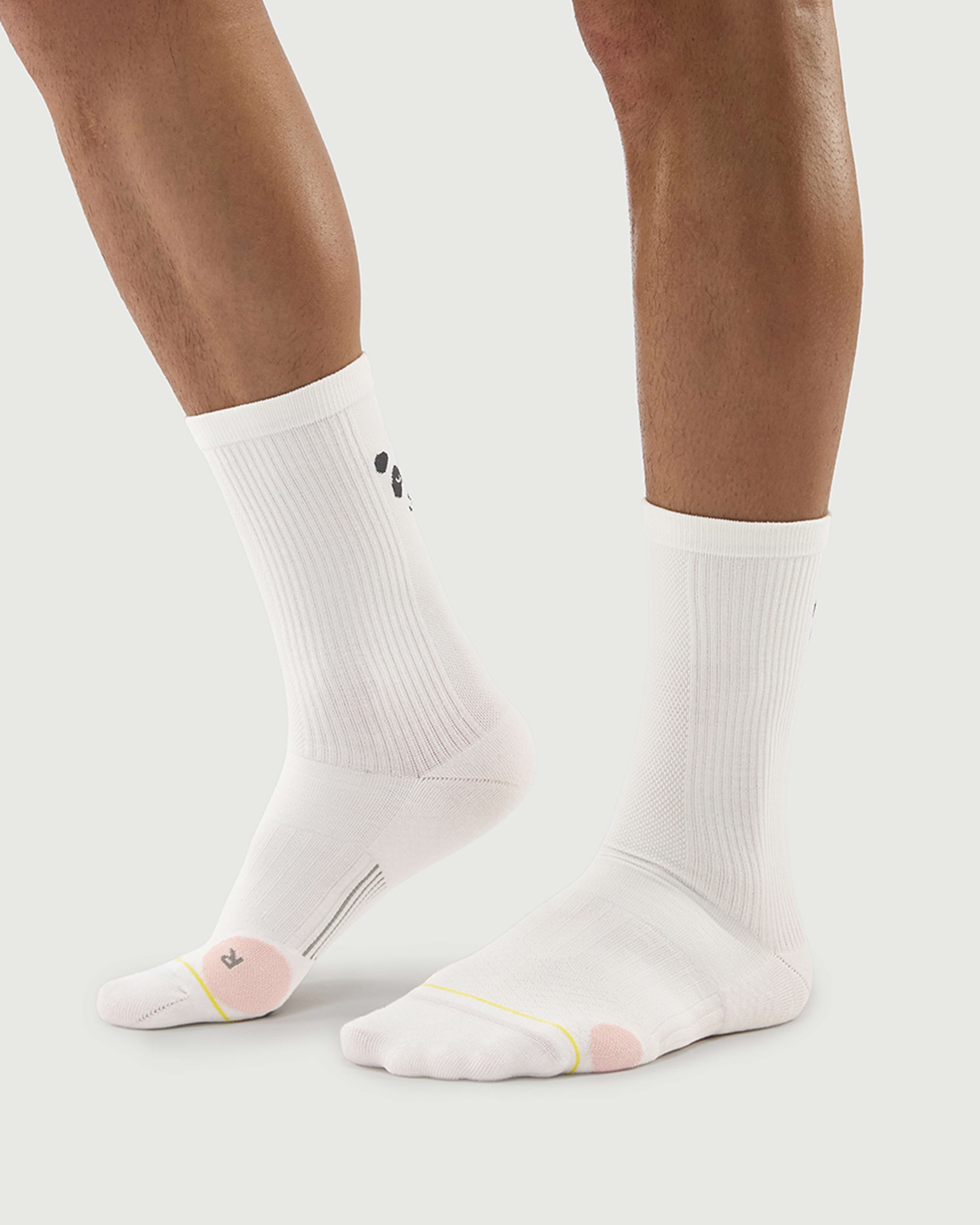 Side view of white Naughty Panda socks on a model, highlighting the athletic crew height.