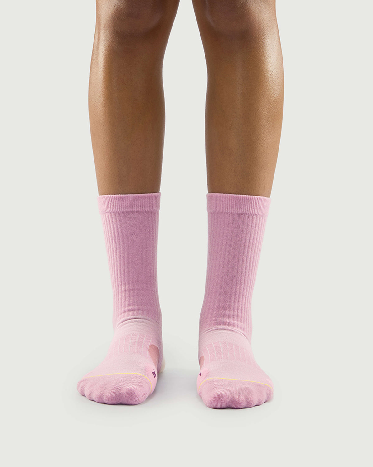 Front view of a model wearing pink Sakura Snowman socks, showing a soft and stylish fit.