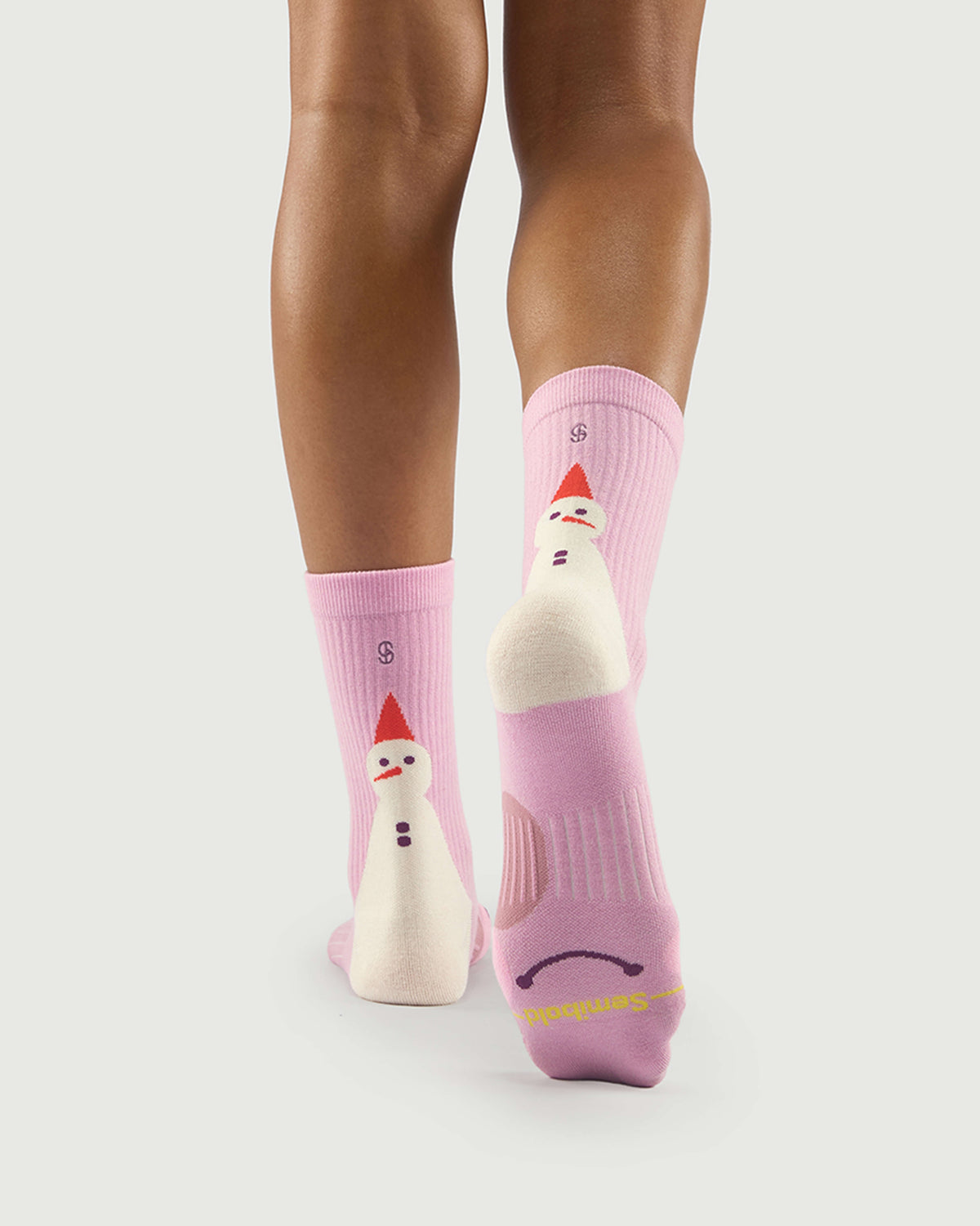 Sole view of pink Sakura Snowman socks on a model, showcasing the supportive arch knit.
