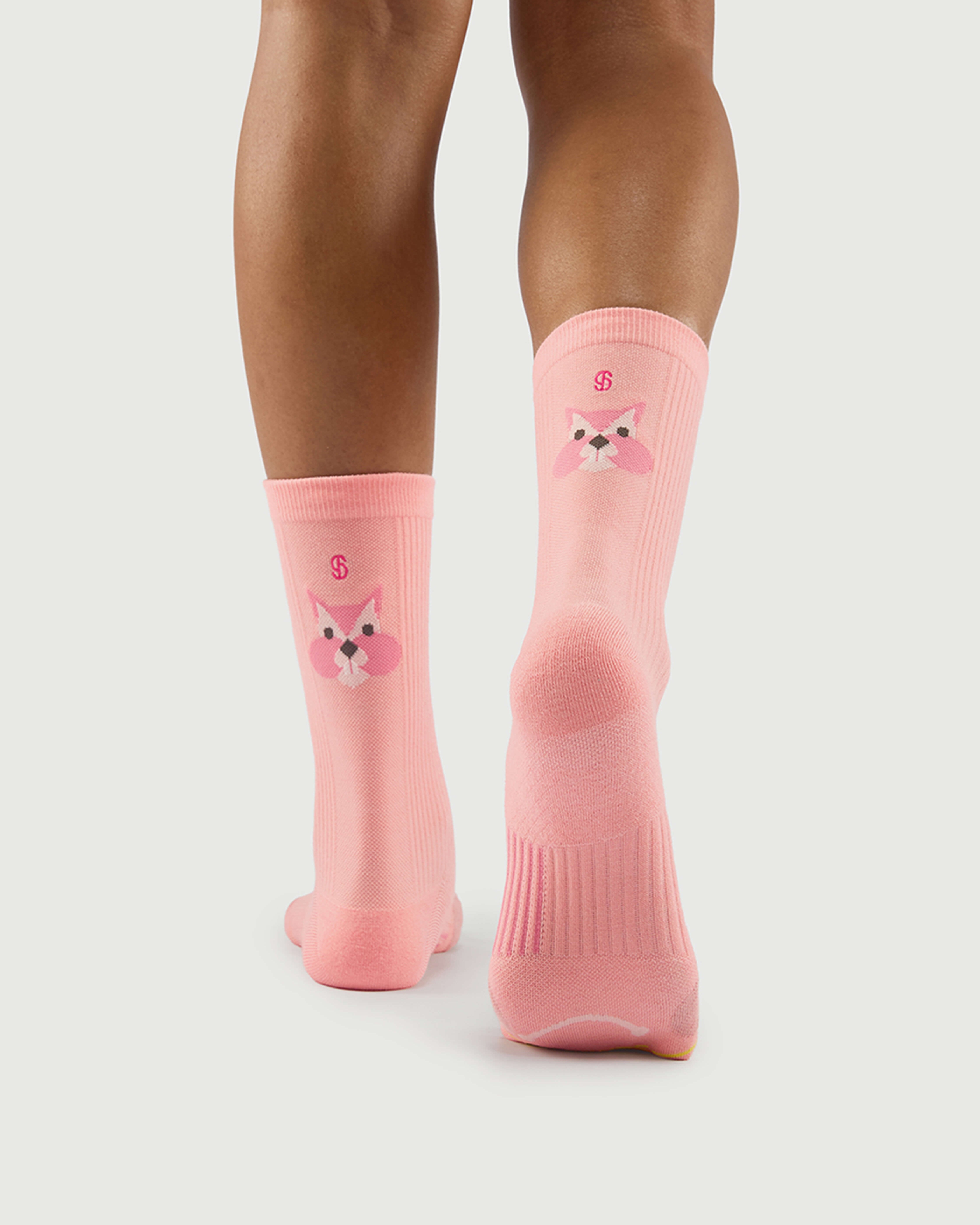 Back view of peach Savoring Squirrel socks on a model, featuring the squirrel character and arch support.