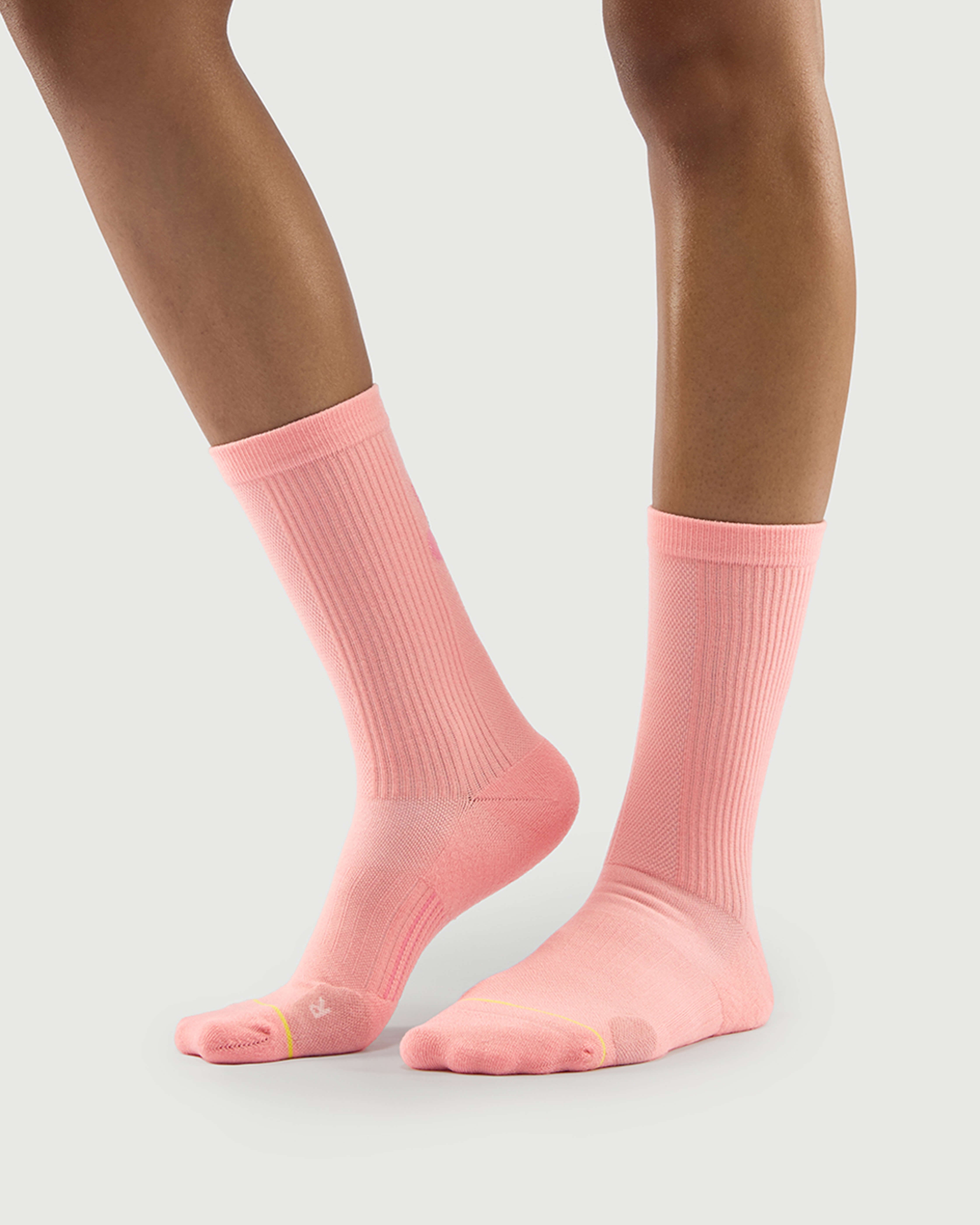 Side view of peach Savoring Squirrel socks on a model, showing the reinforced lateral toe cushion.
