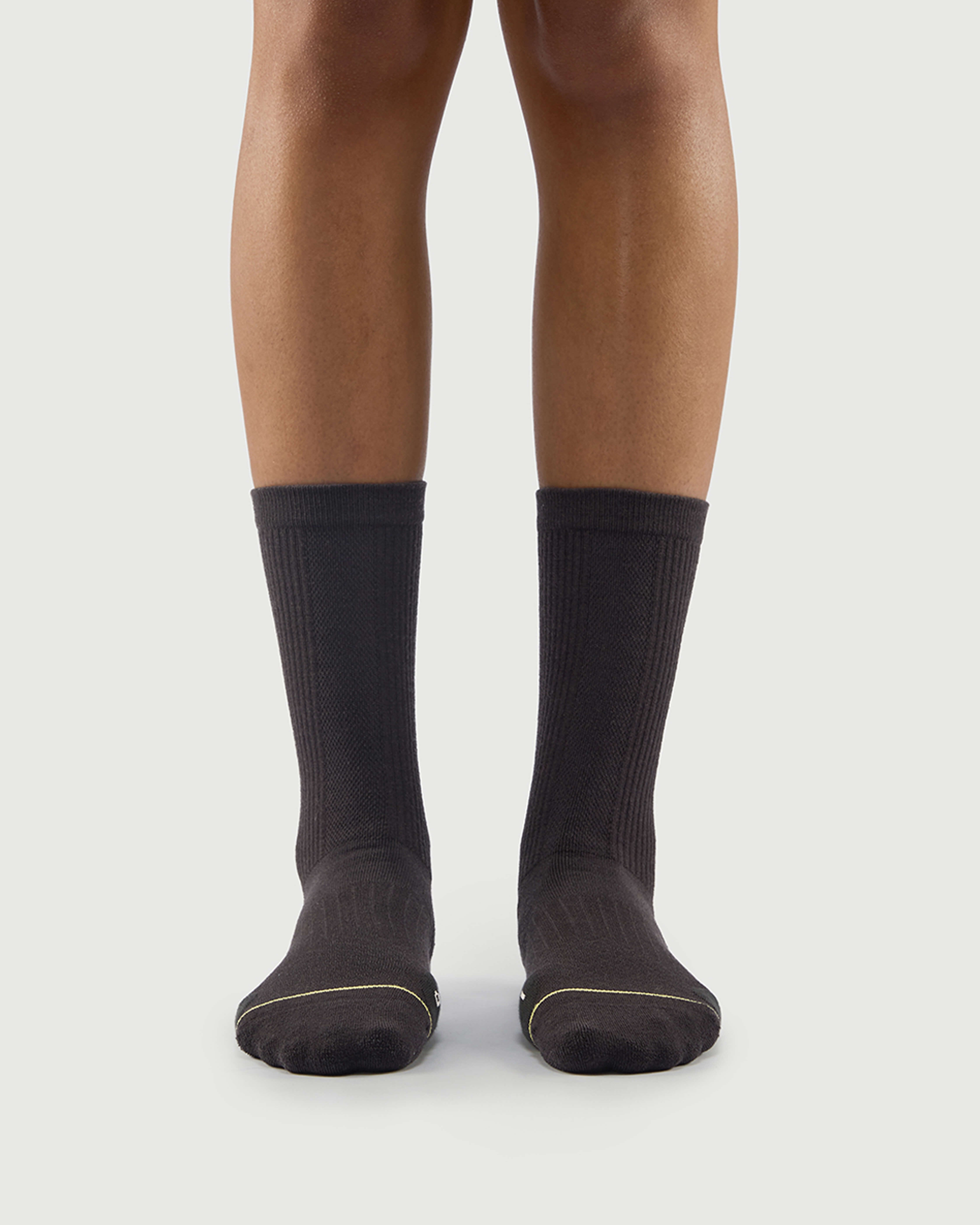 Front view of a model wearing grey Scrubby Raccoon socks, built for outdoor adventure.
