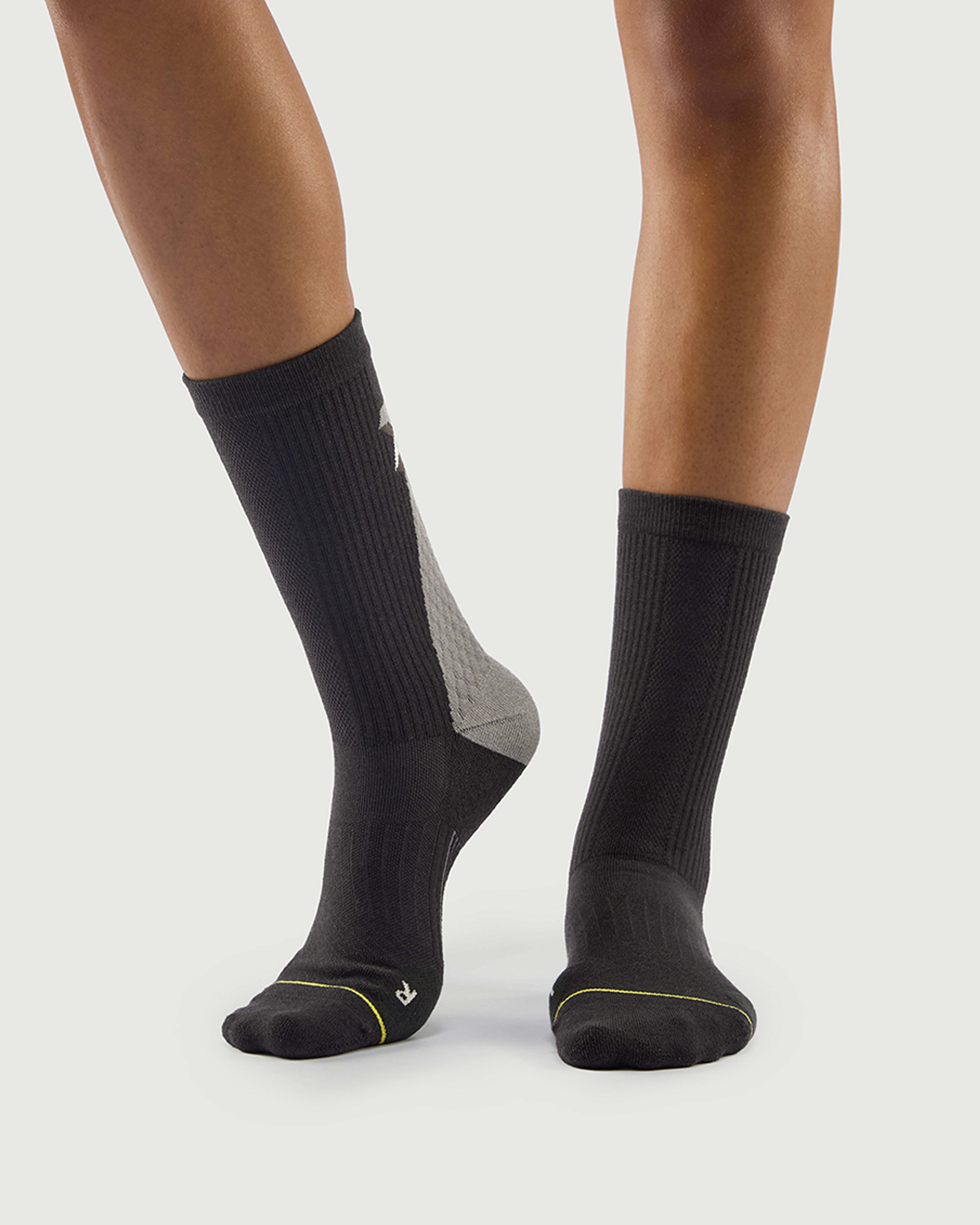 Side view of grey Scrubby Raccoon hiking socks on a model, showing the durable ribbing.
