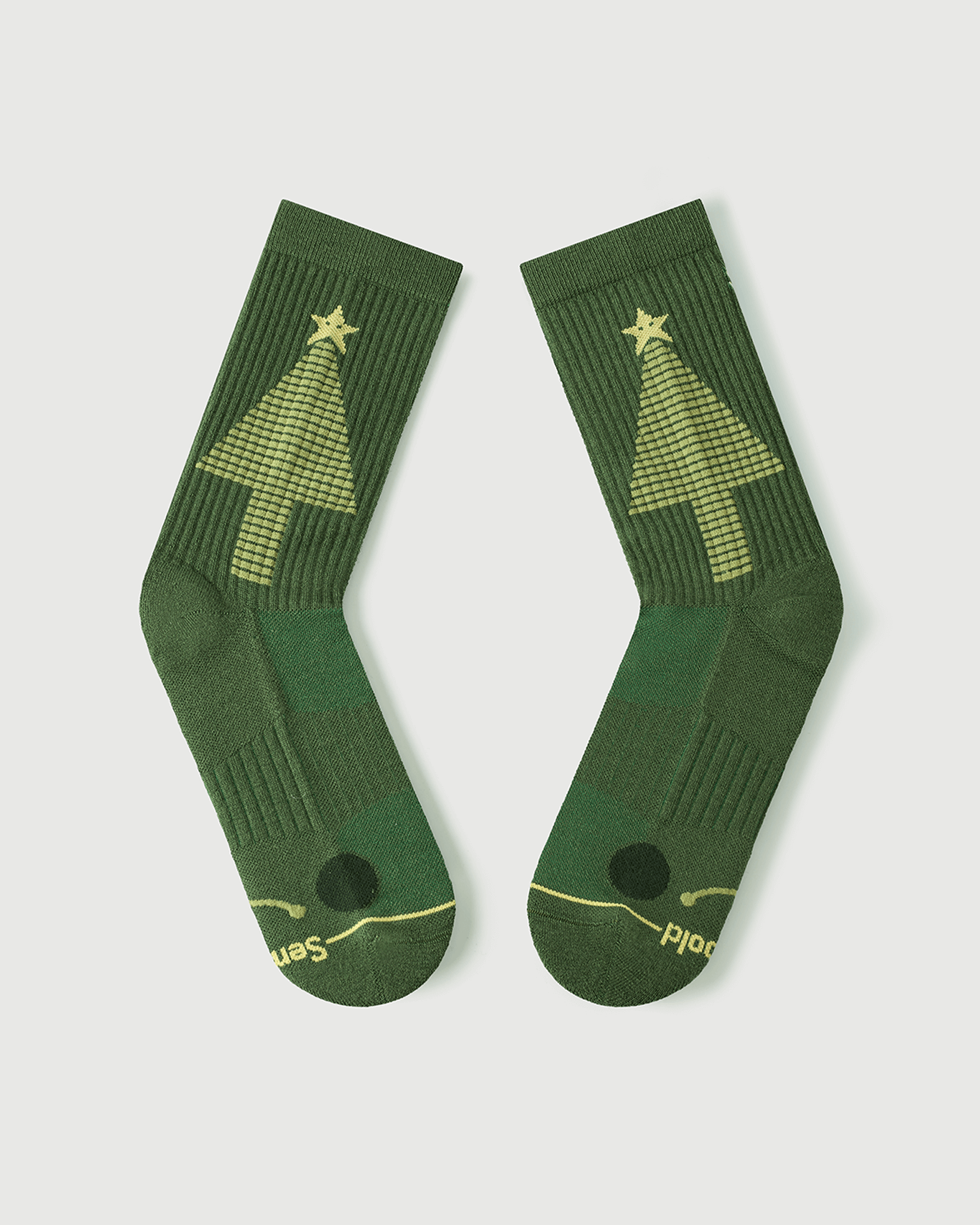 Detailed view of Starry Pine Merino wool socks showing the targeted toe cushioning and the iconic yellow Christmas tree graphic.