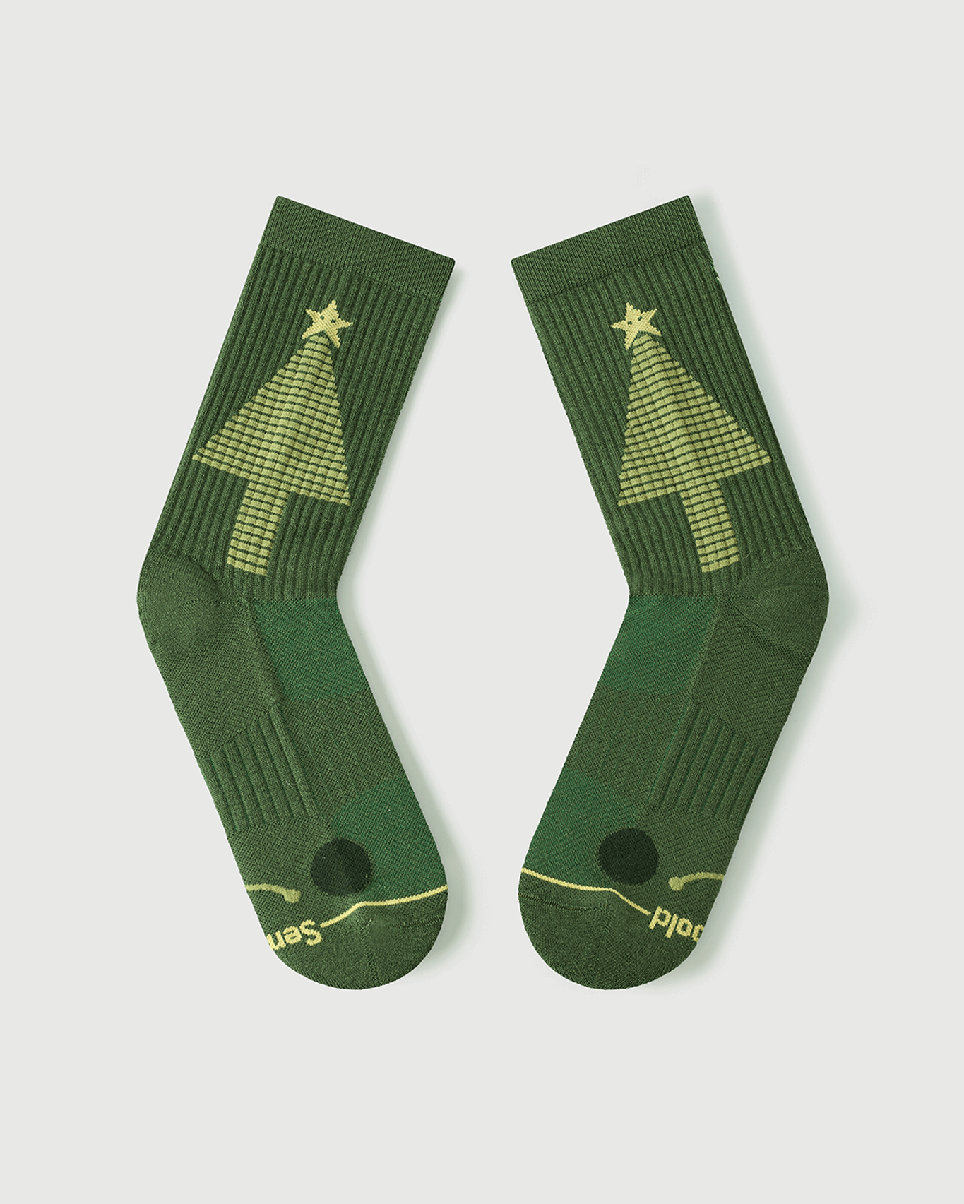 Detailed view of Starry Pine Merino wool socks showing the targeted toe cushioning and the iconic yellow Christmas tree graphic.