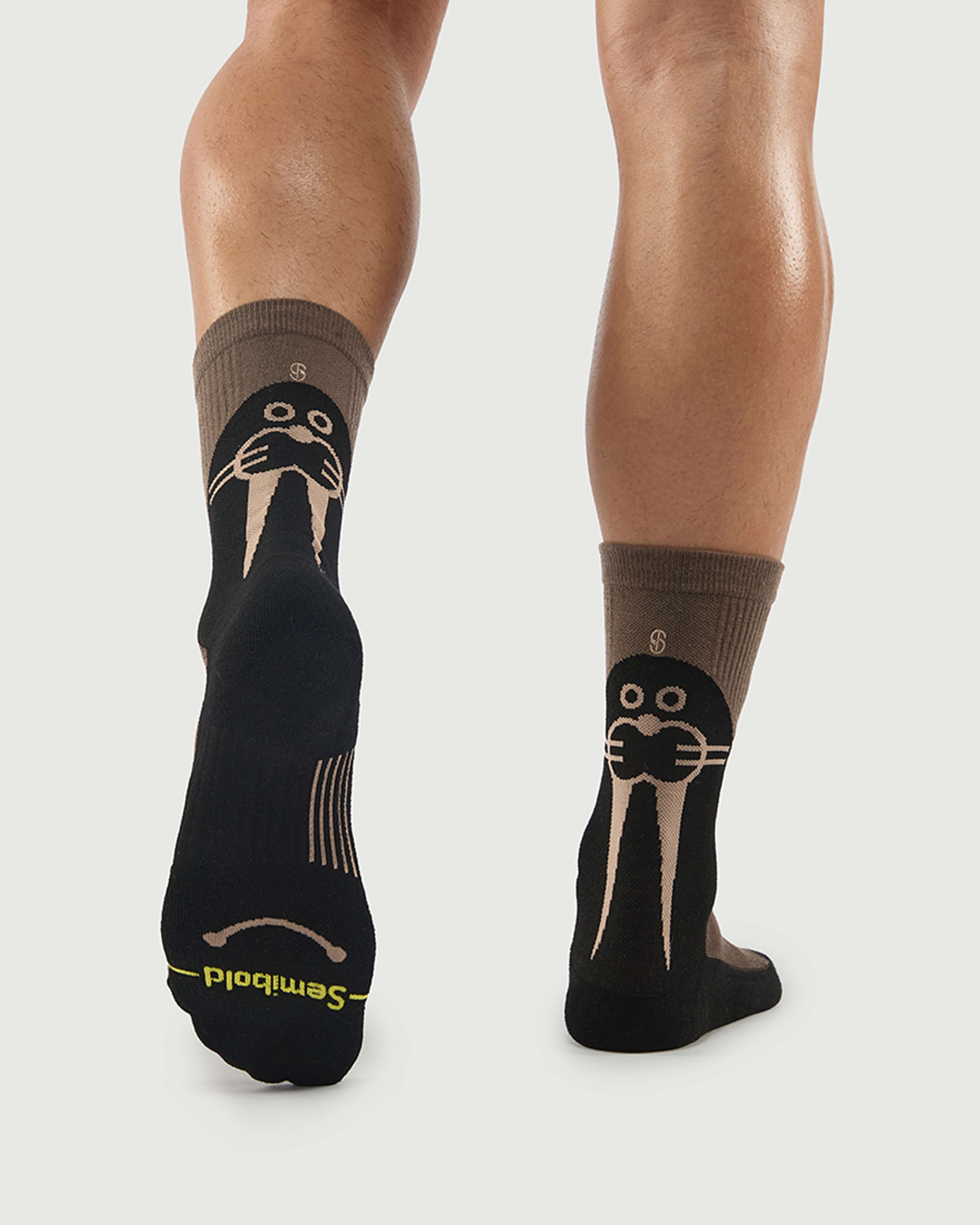 Back view of Whiz Walrus socks on a model, showing the walrus character and sole arch support.