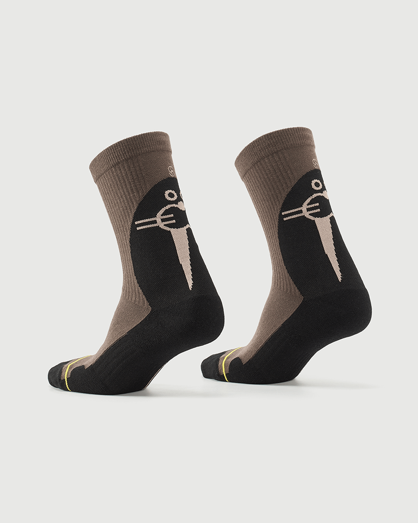 Whiz Walrus black and brown socks on a foot form, showing the character pattern on the heel.