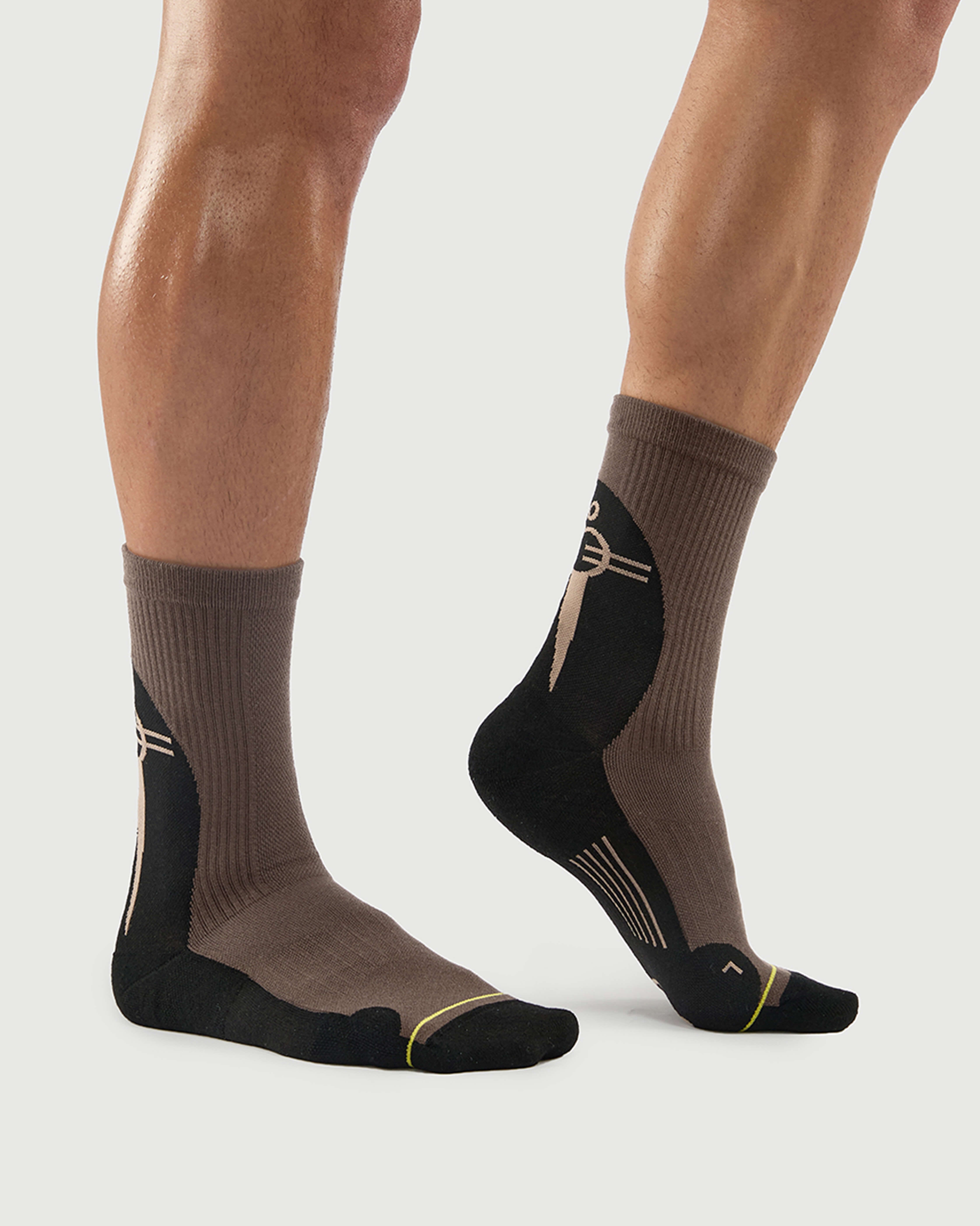 Side view of Whiz Walrus socks on a model, showcasing the split-color black and brown design.