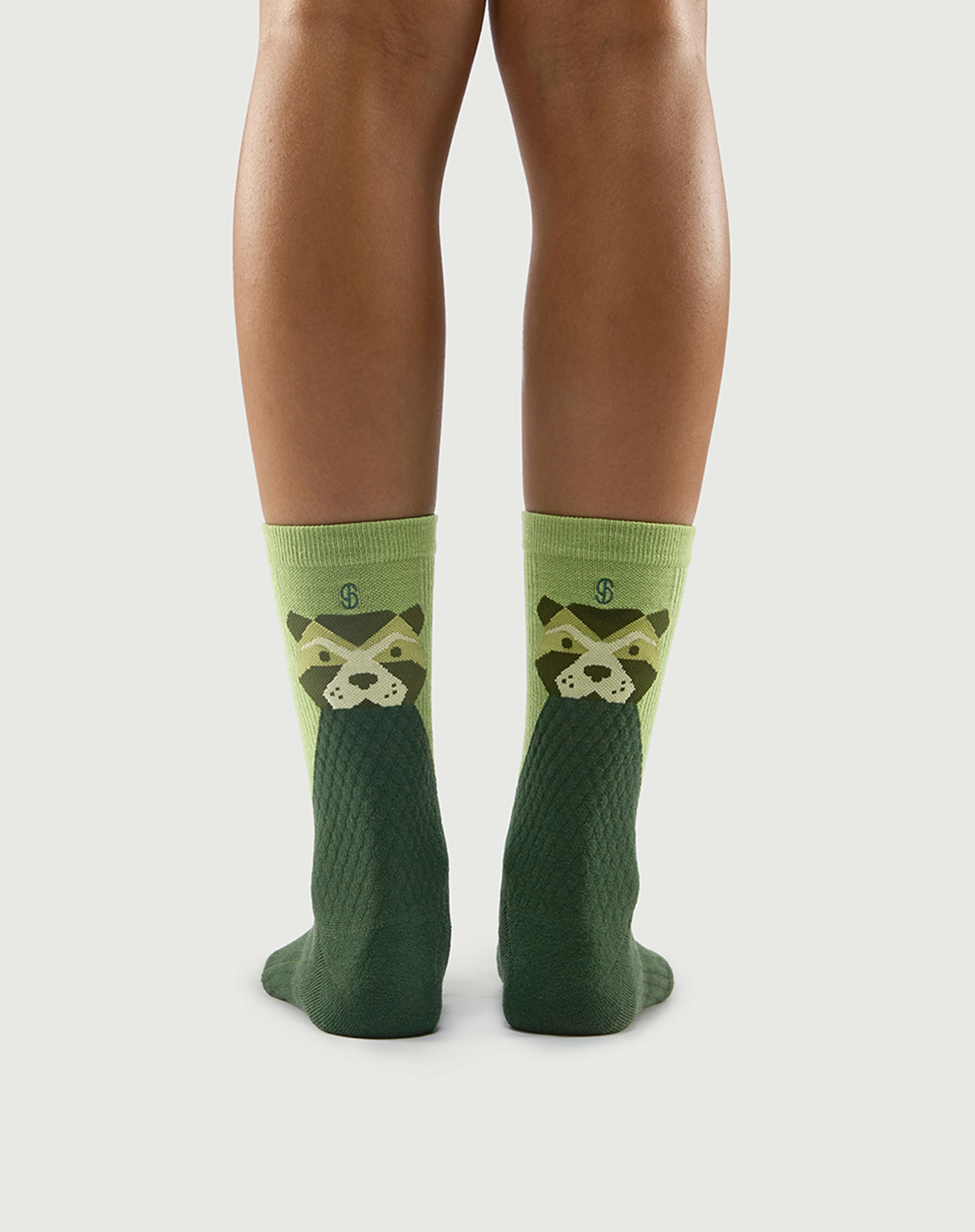 Back view of green Crafty Otter socks on a model, showcasing the otter character design.