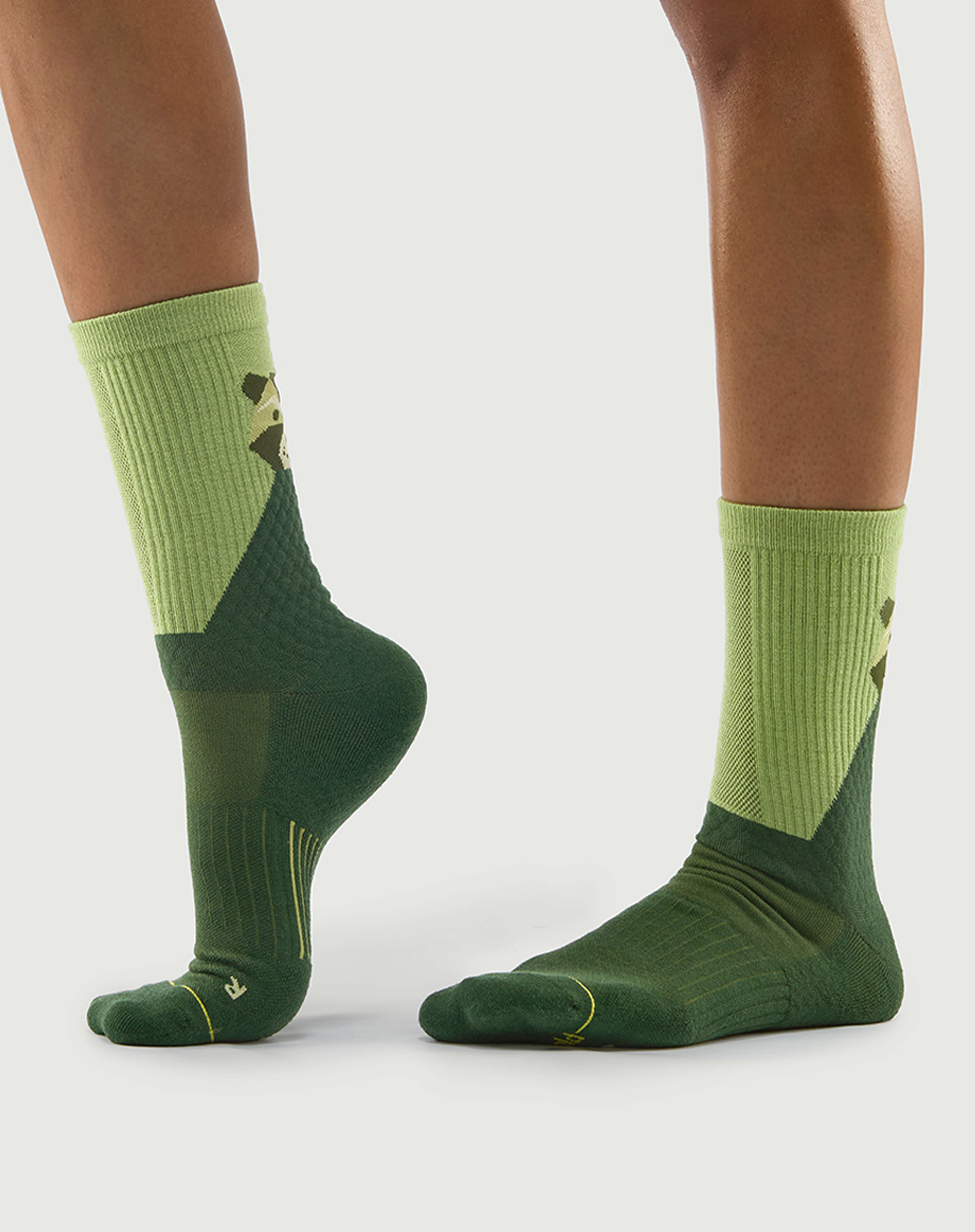 Side view of green Crafty Otter hiking socks on a model, highlighting the color-block design.