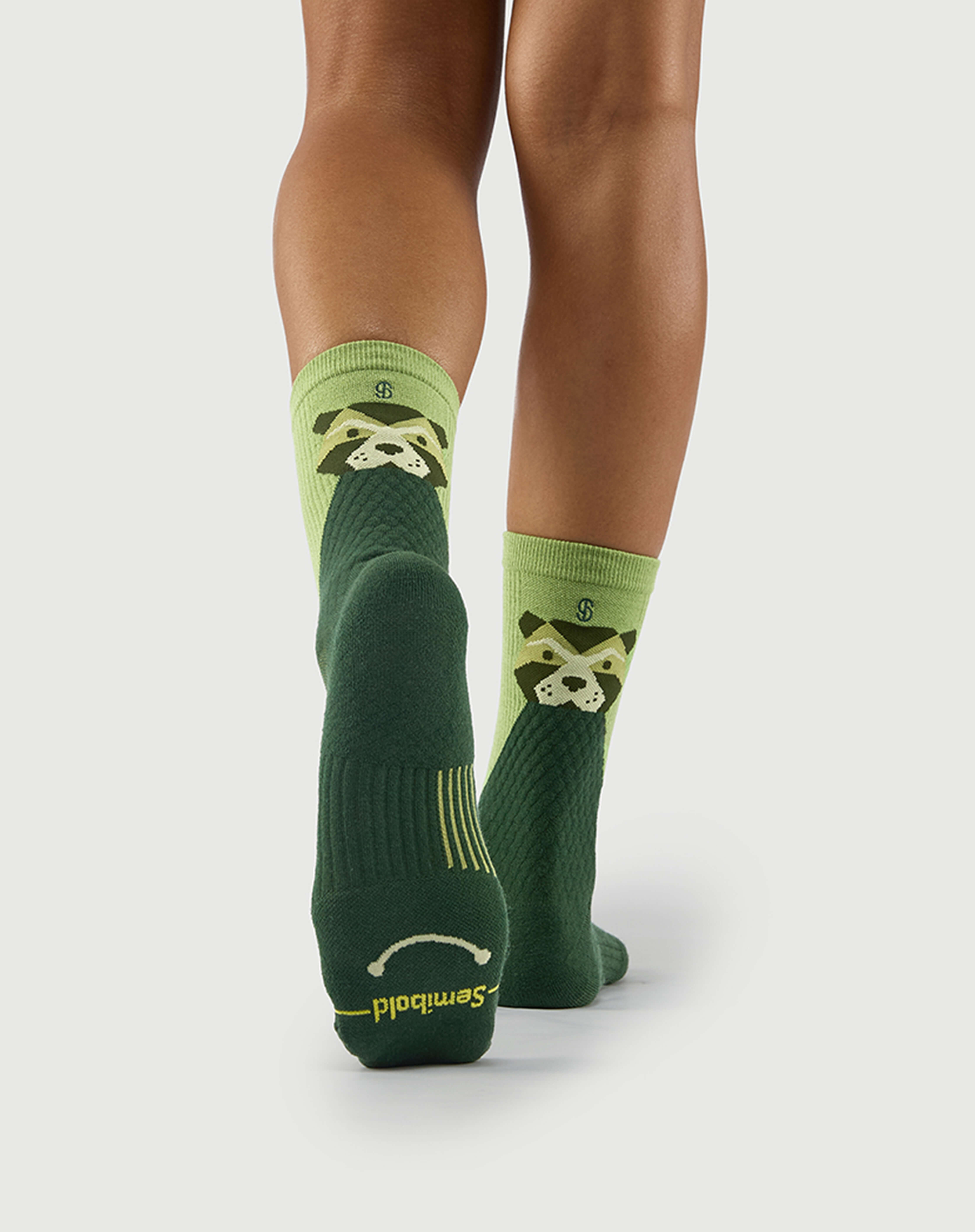 Bottom view of green Crafty Otter socks on a model, showing the technical arch support on the sole.