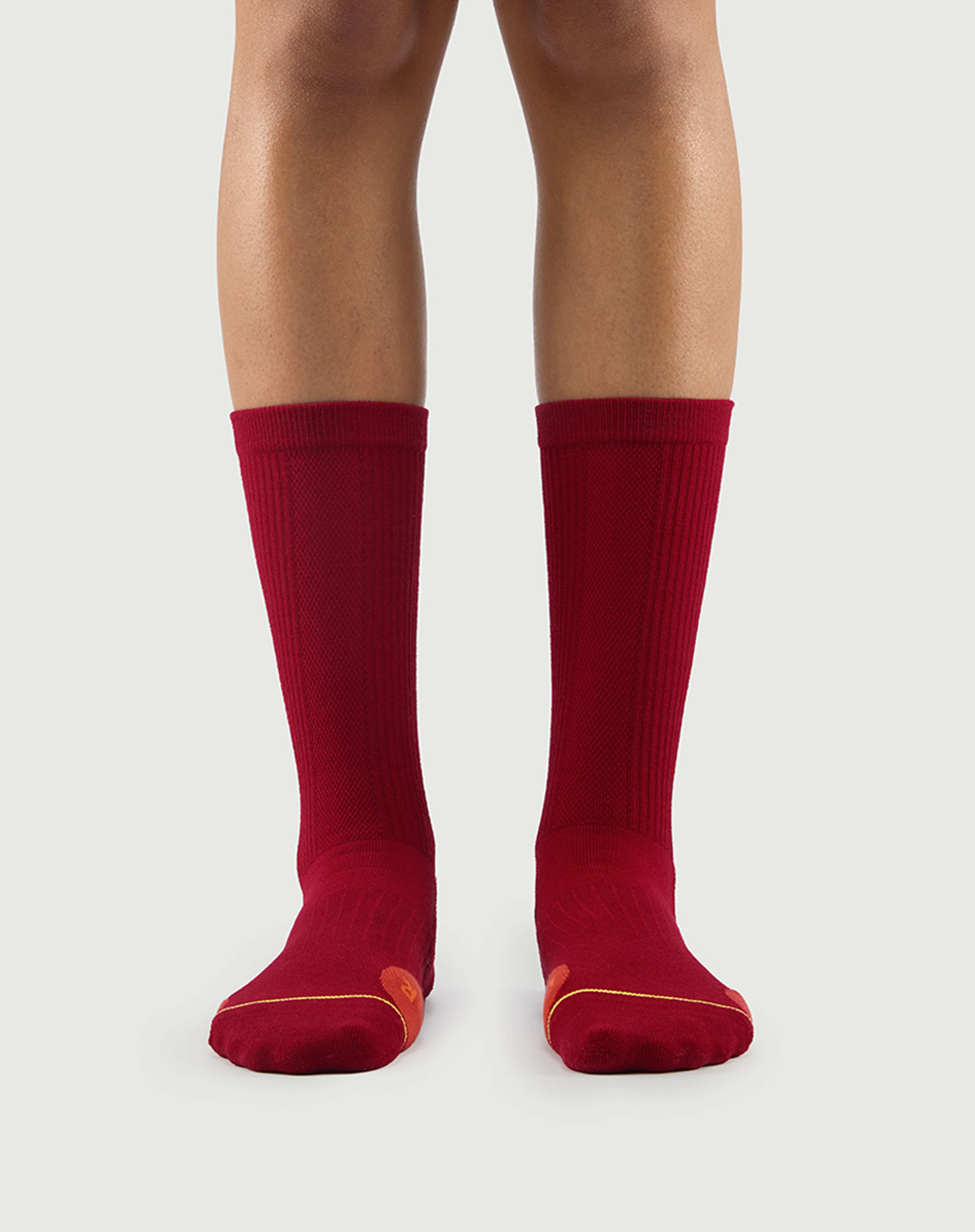 Front view of red Devoted Fox socks on a model, vibrant color for hiking and everyday wear.