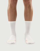 Front view of white Naughty Panda socks on a model, showcasing a clean minimalist style.