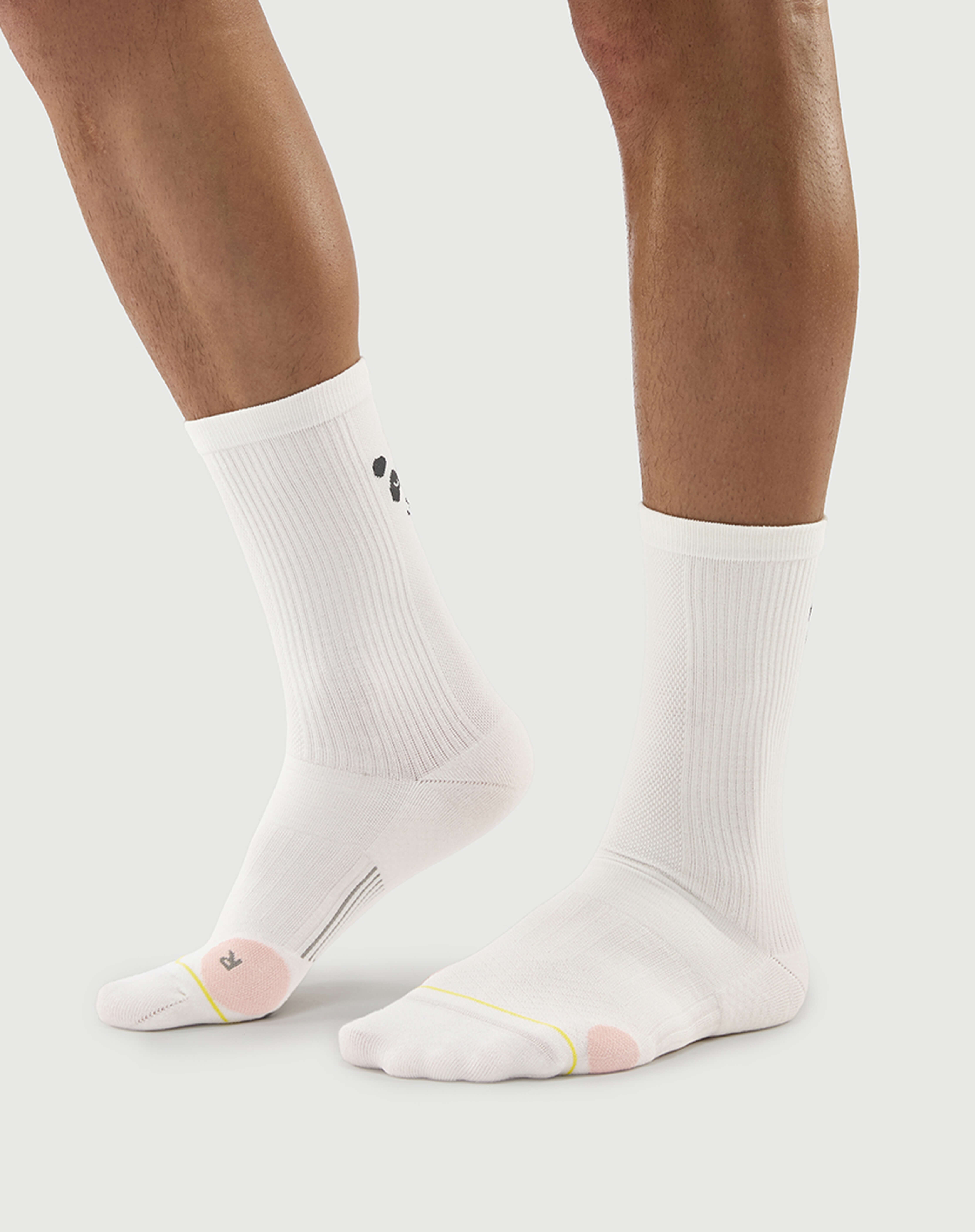 Side view of white Naughty Panda socks on a model, highlighting the athletic crew height.