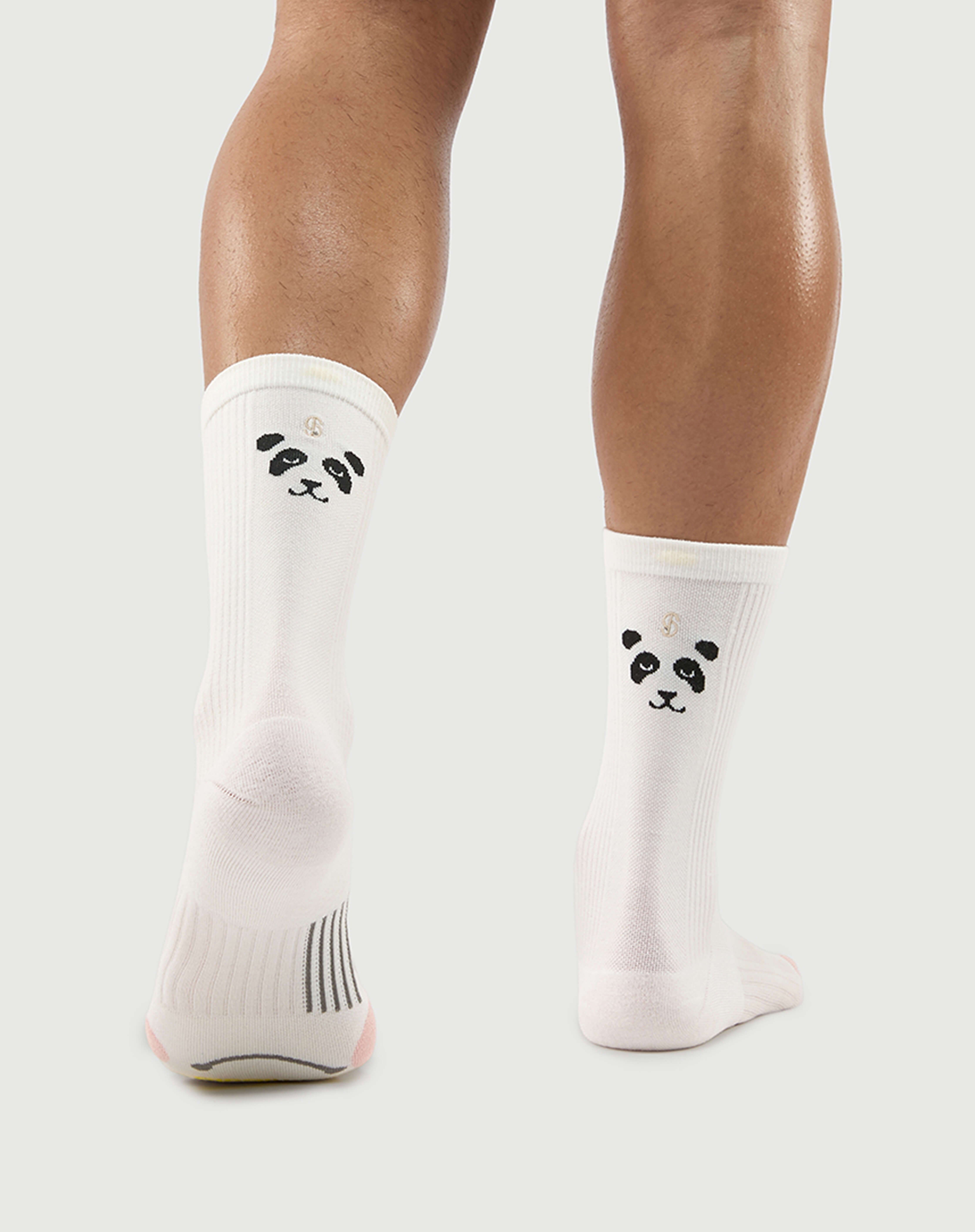 Bottom view of white Naughty Panda socks on a model, showing the dynamic arch support zone.