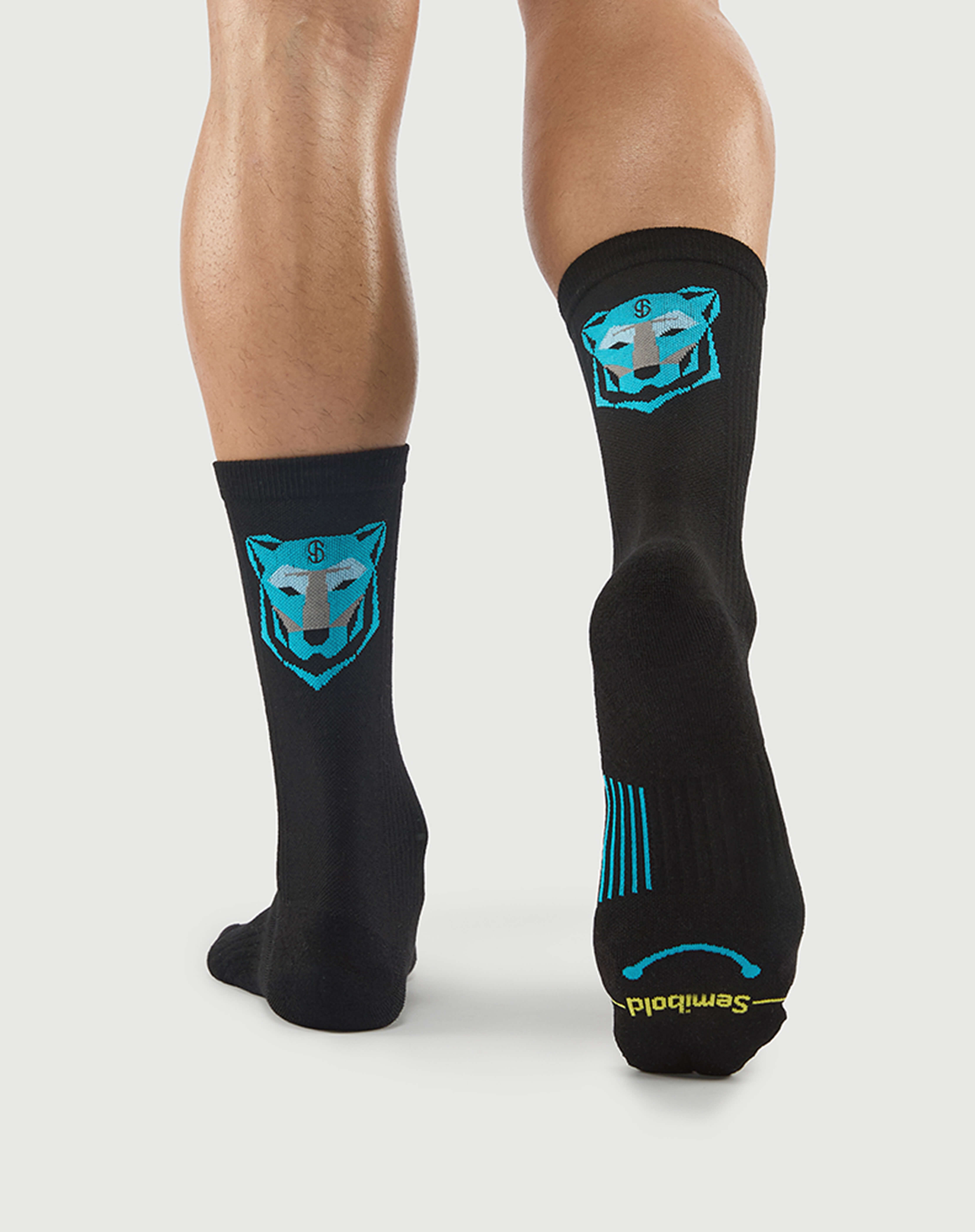 Back view of black Regal Tiger socks on a model, featuring the blue tiger face and visible arch support.