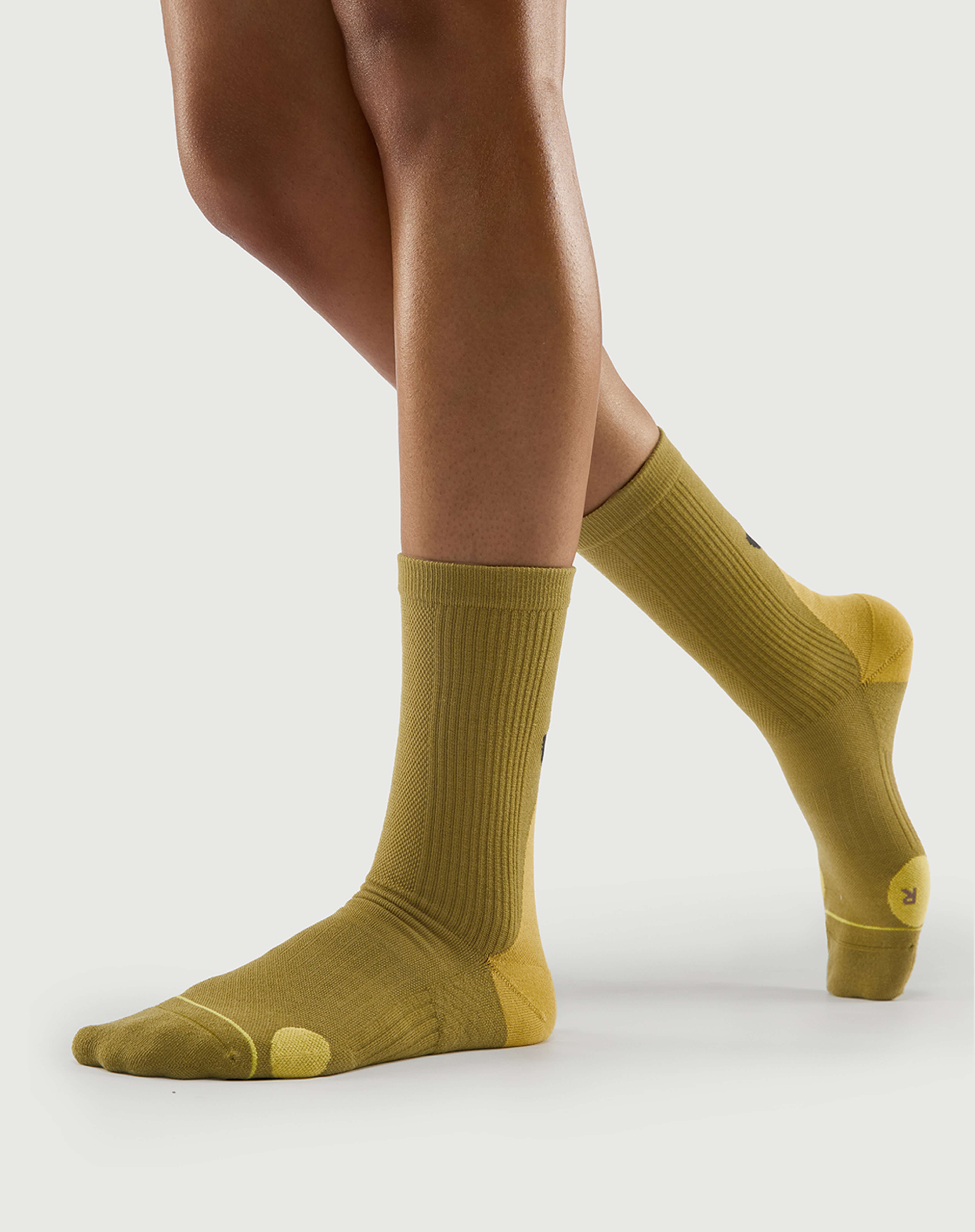 Side view of yellow Royal Puffin socks on a model, highlighting the targeted lateral toe cushion.