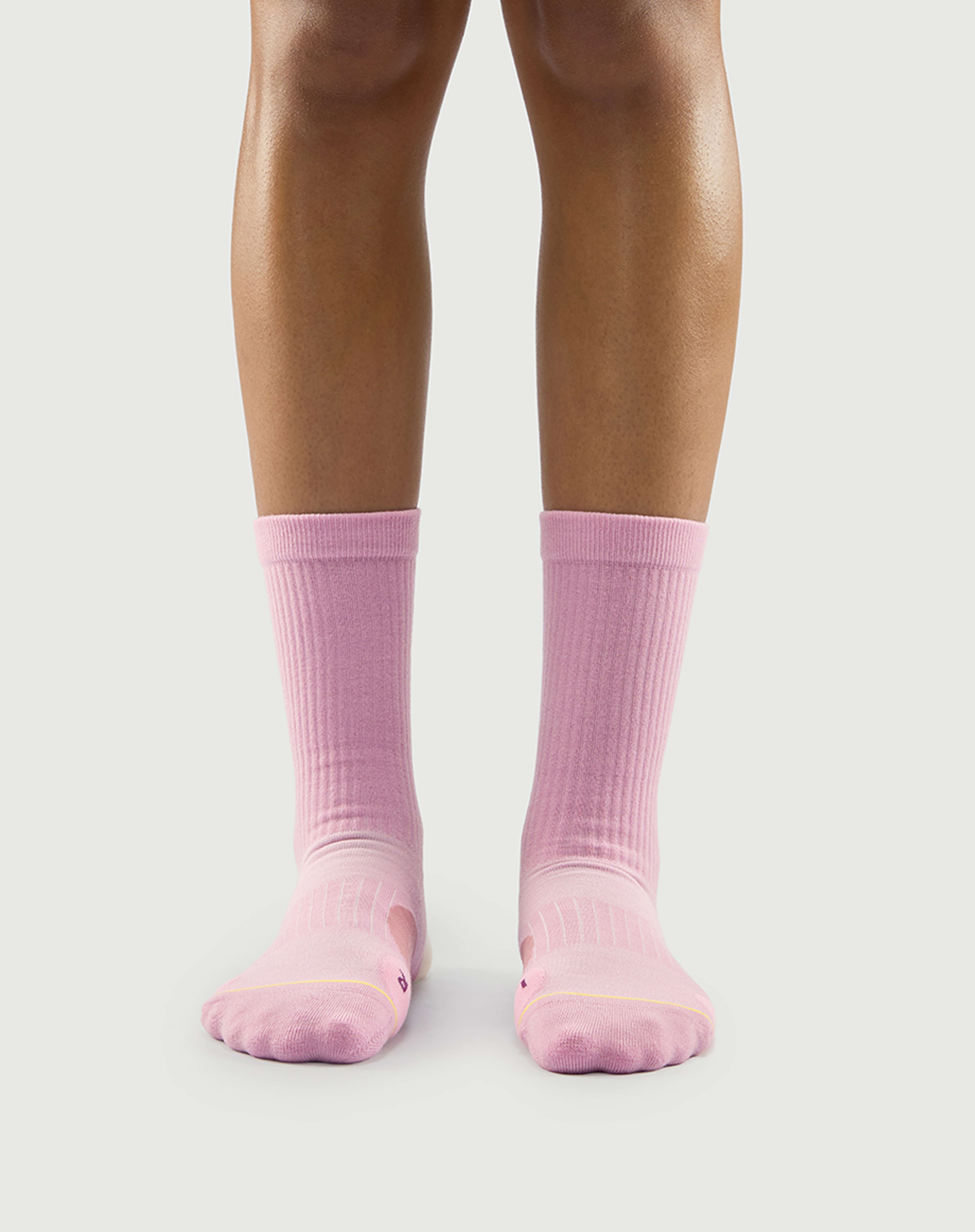 Front view of a model wearing pink Sakura Snowman socks, showing a soft and stylish fit.