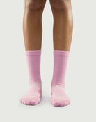 Front view of a model wearing pink Sakura Snowman socks, showing a soft and stylish fit.