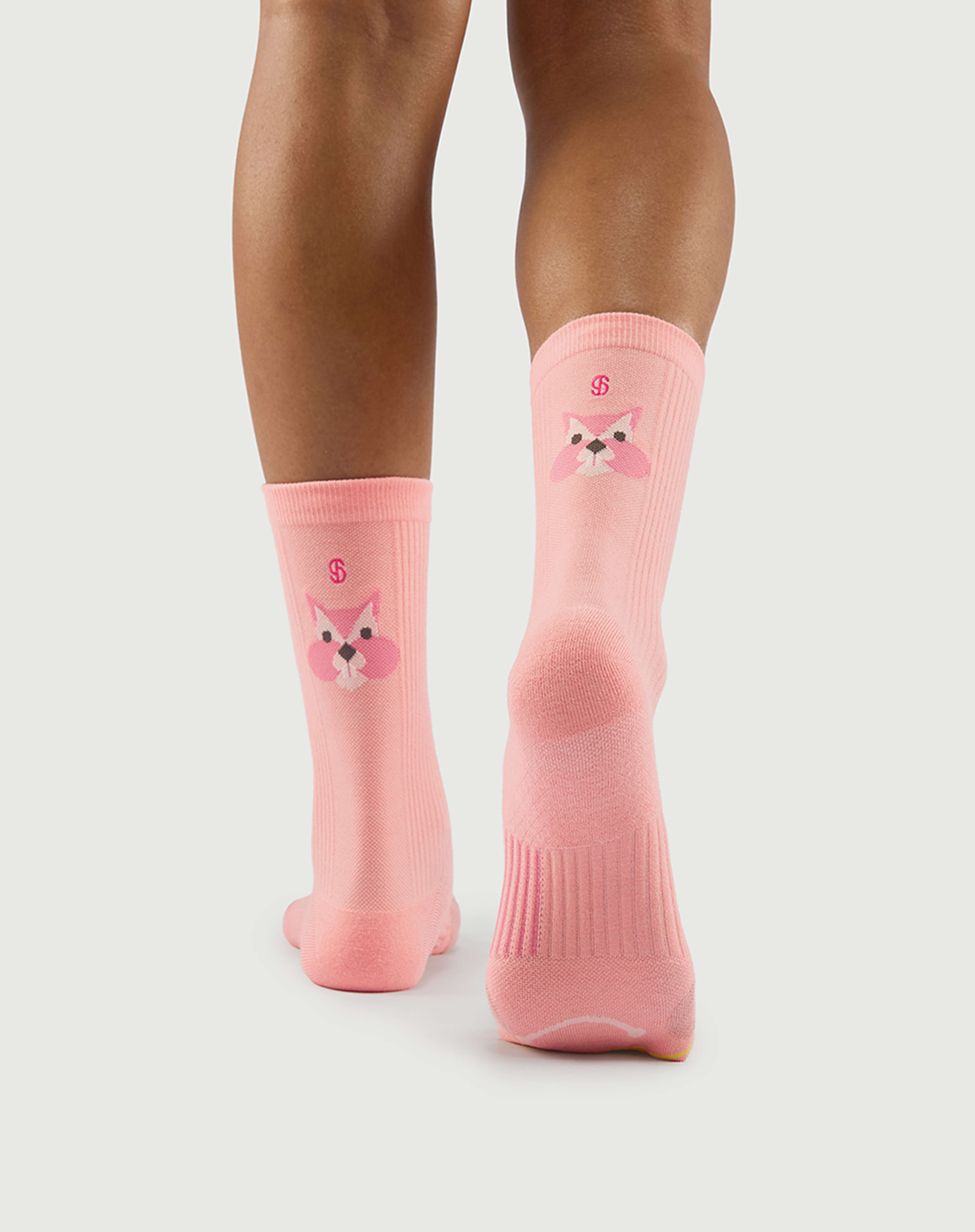 Back view of peach Savoring Squirrel socks on a model, featuring the squirrel character and arch support.