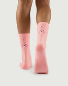 Back view of peach Savoring Squirrel socks on a model, featuring the squirrel character and arch support.