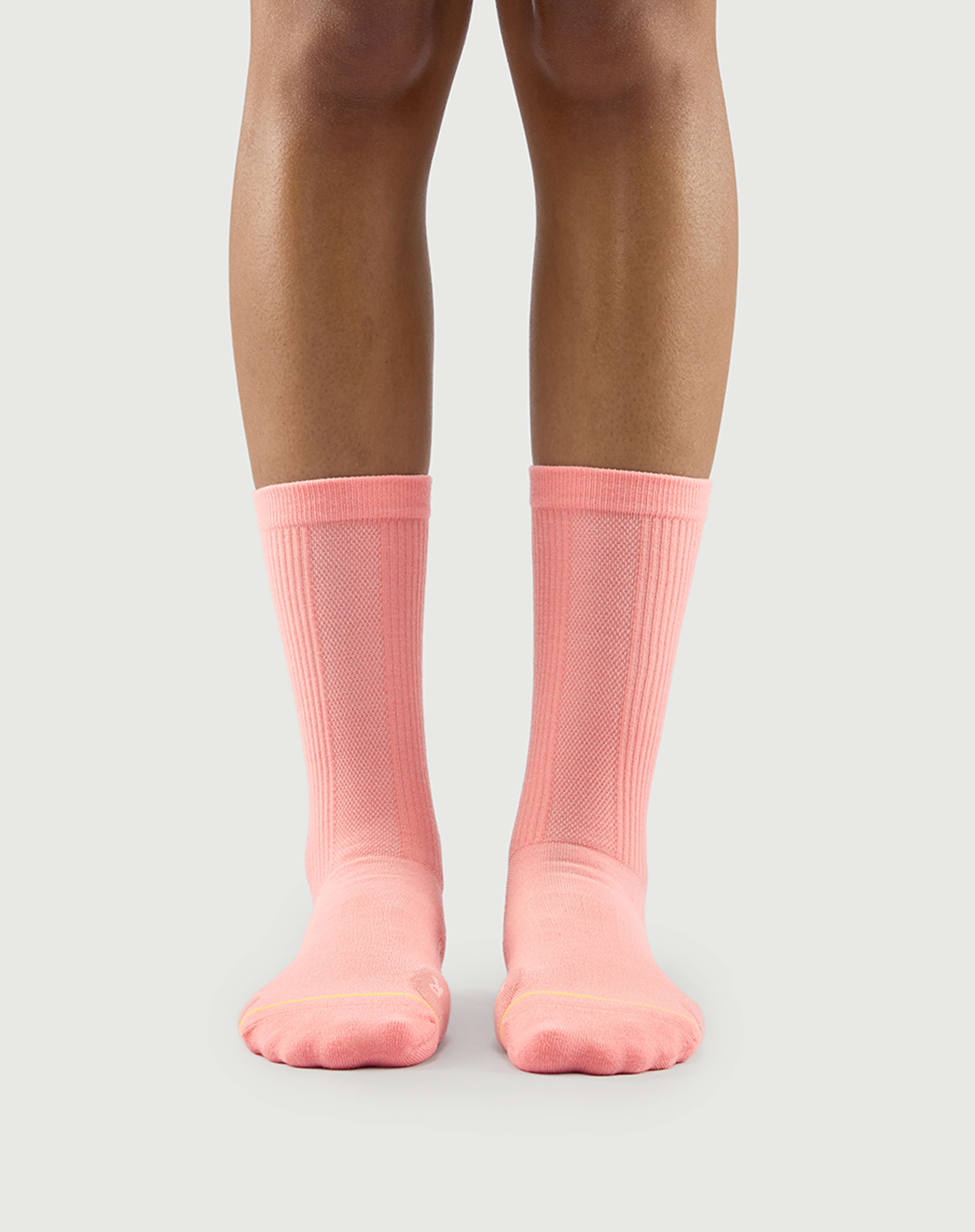 Front view of peach Savoring Squirrel socks on a model, a soft and warm tone for outdoor activities.