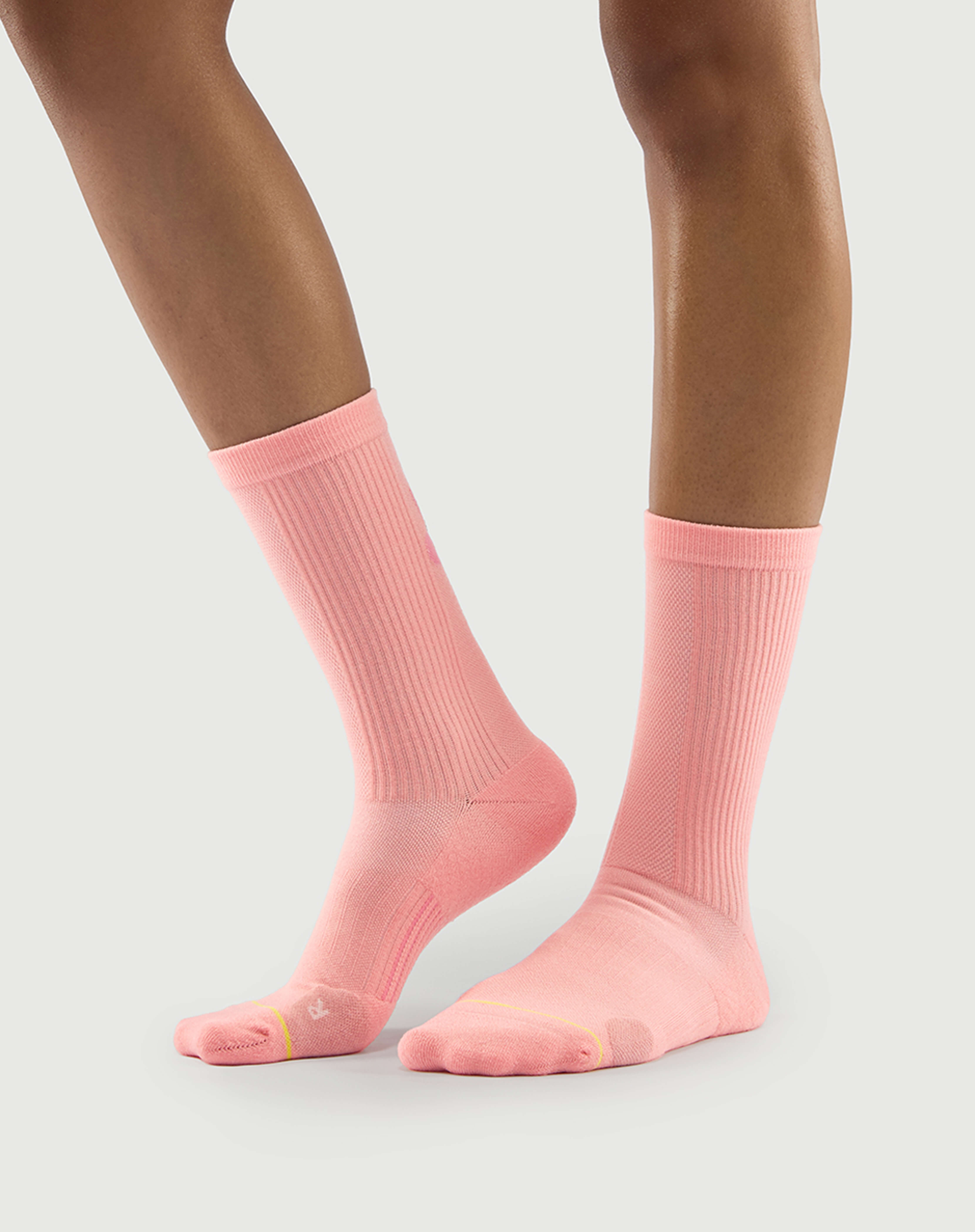 Side view of peach Savoring Squirrel socks on a model, showing the reinforced lateral toe cushion.