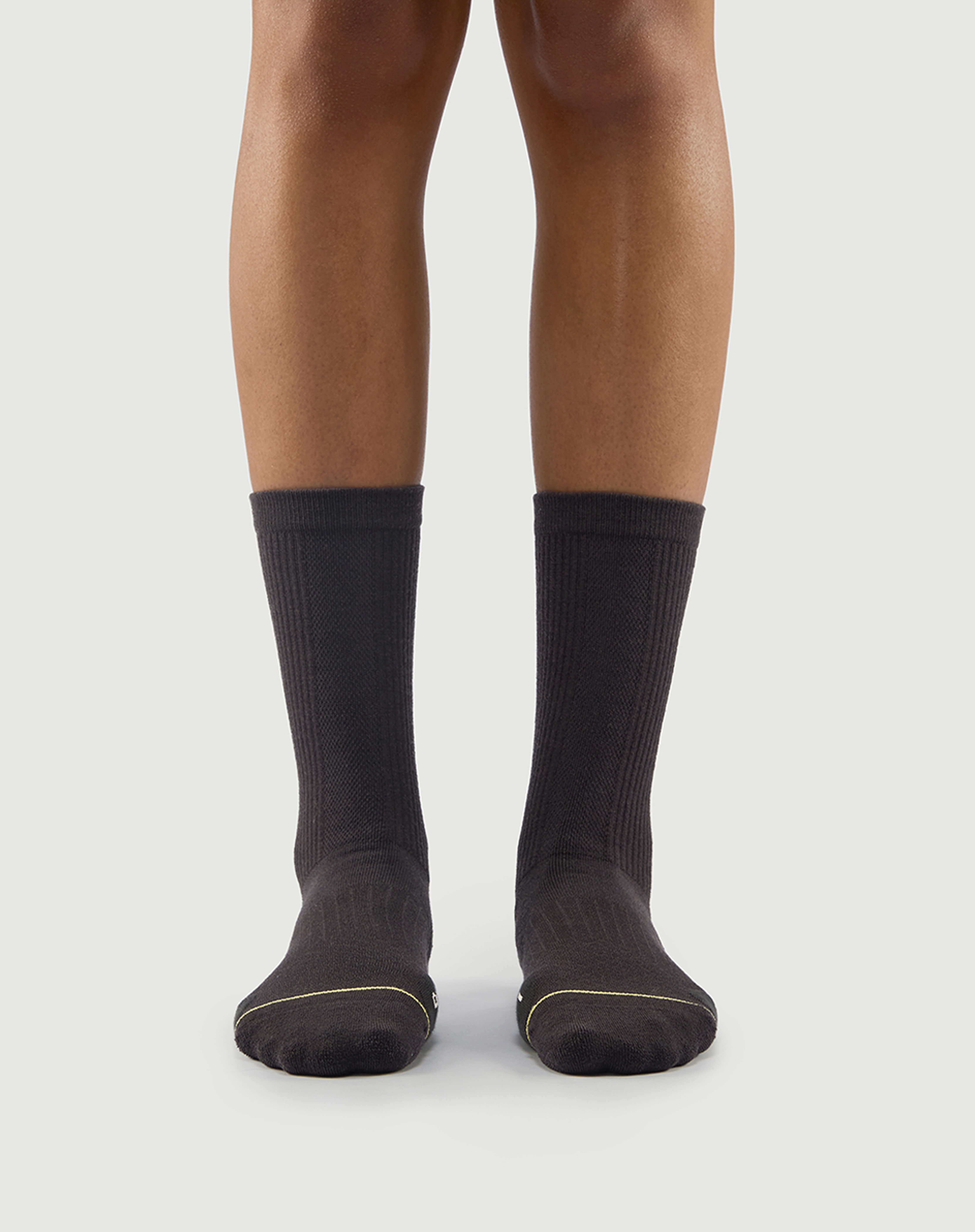 Front view of a model wearing grey Scrubby Raccoon socks, built for outdoor adventure.