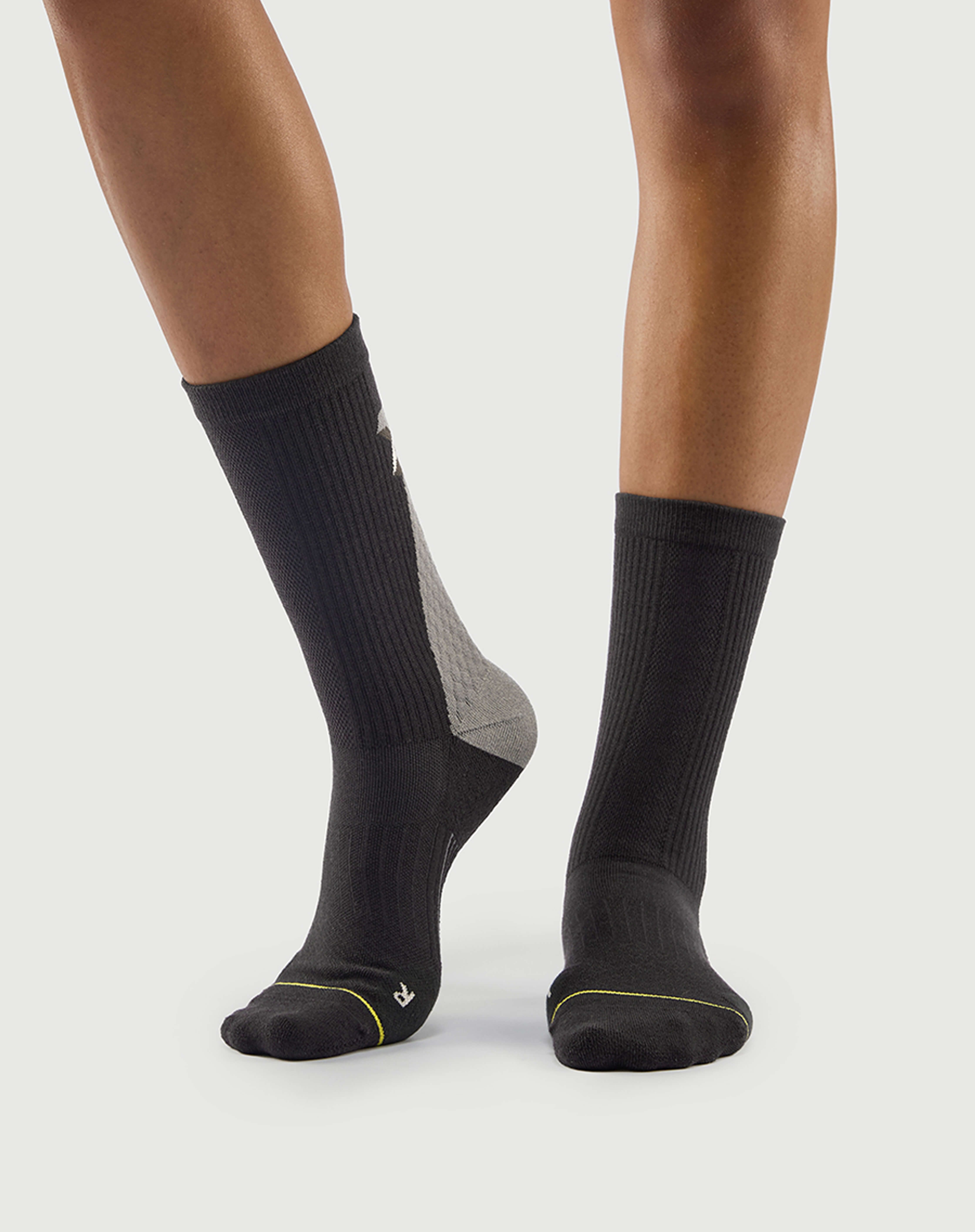 Side view of grey Scrubby Raccoon hiking socks on a model, showing the durable ribbing.