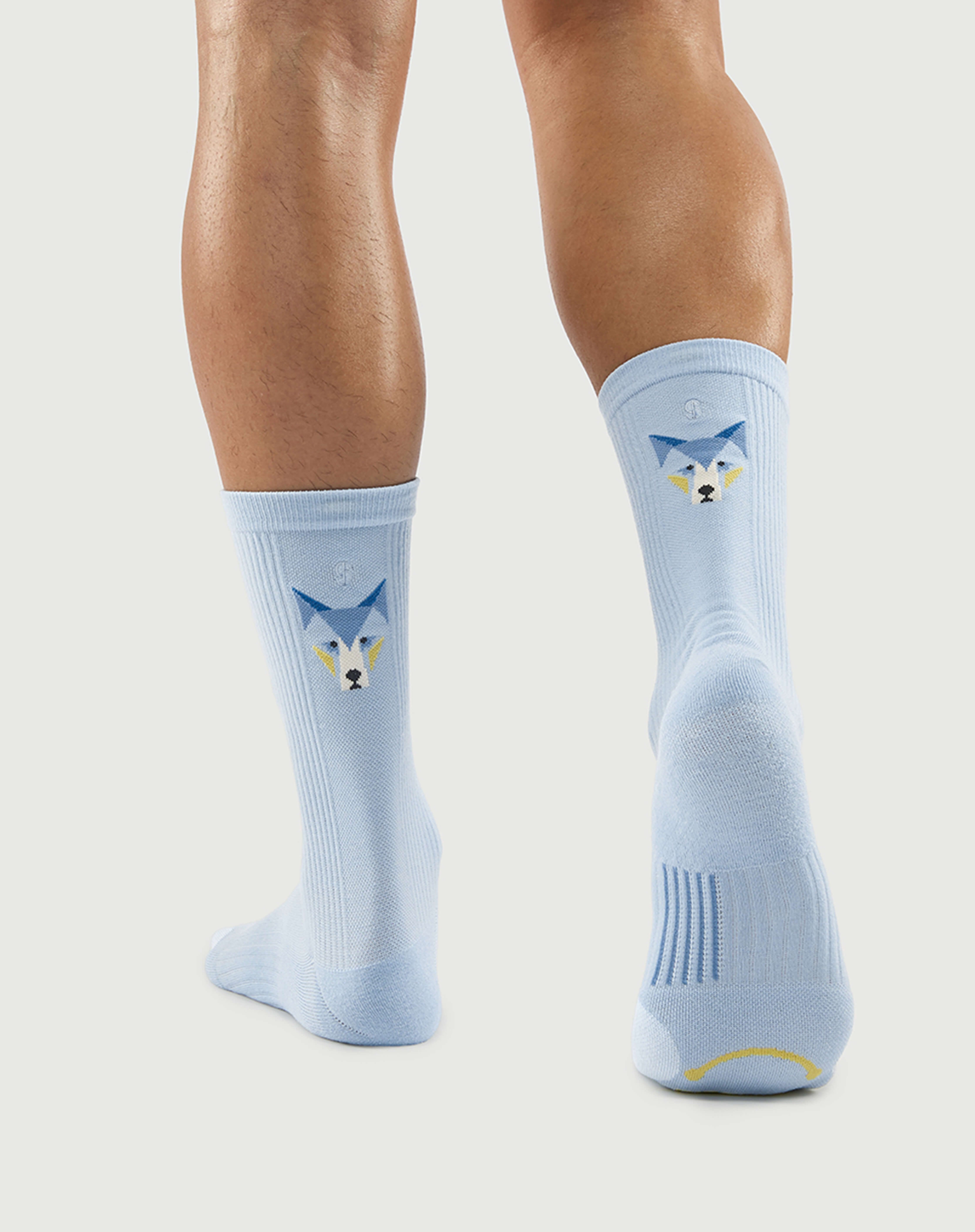 Bottom view of light blue Silent Wolf socks on a model, highlighting the targeted arch support zones.