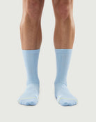 Front view of a model wearing blue Silent Wolf Merino wool socks with a comfortable ribbed design.